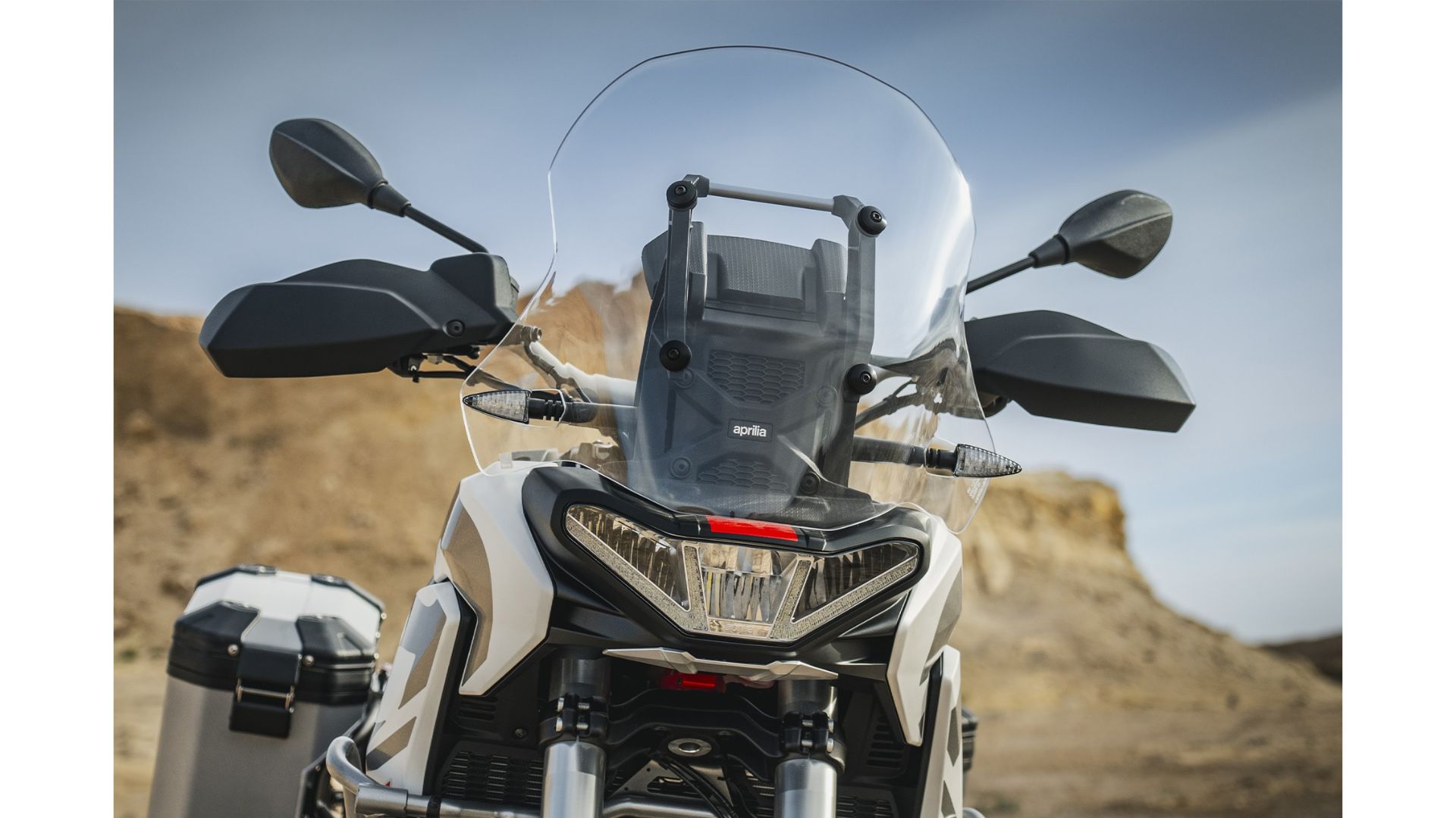 Detajl motorja motocikla Aprilia Tuareg 660 z aluminijastim ščitnikom karterja in logotipom »Aprilia« na pokrovu agregata.