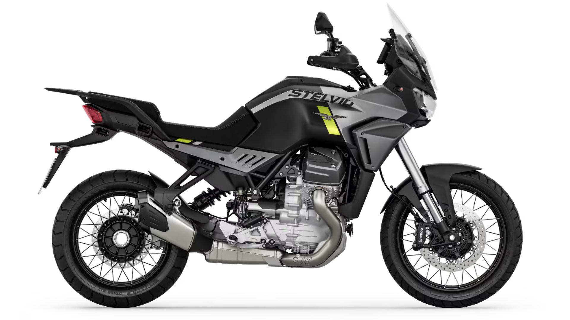 Avanturistični motocikel Moto Guzzi Stelvio v mat črno-sivi kombinaciji z rumenim detajlom, prikazan v levem bočnem profilu na belem ozadju.