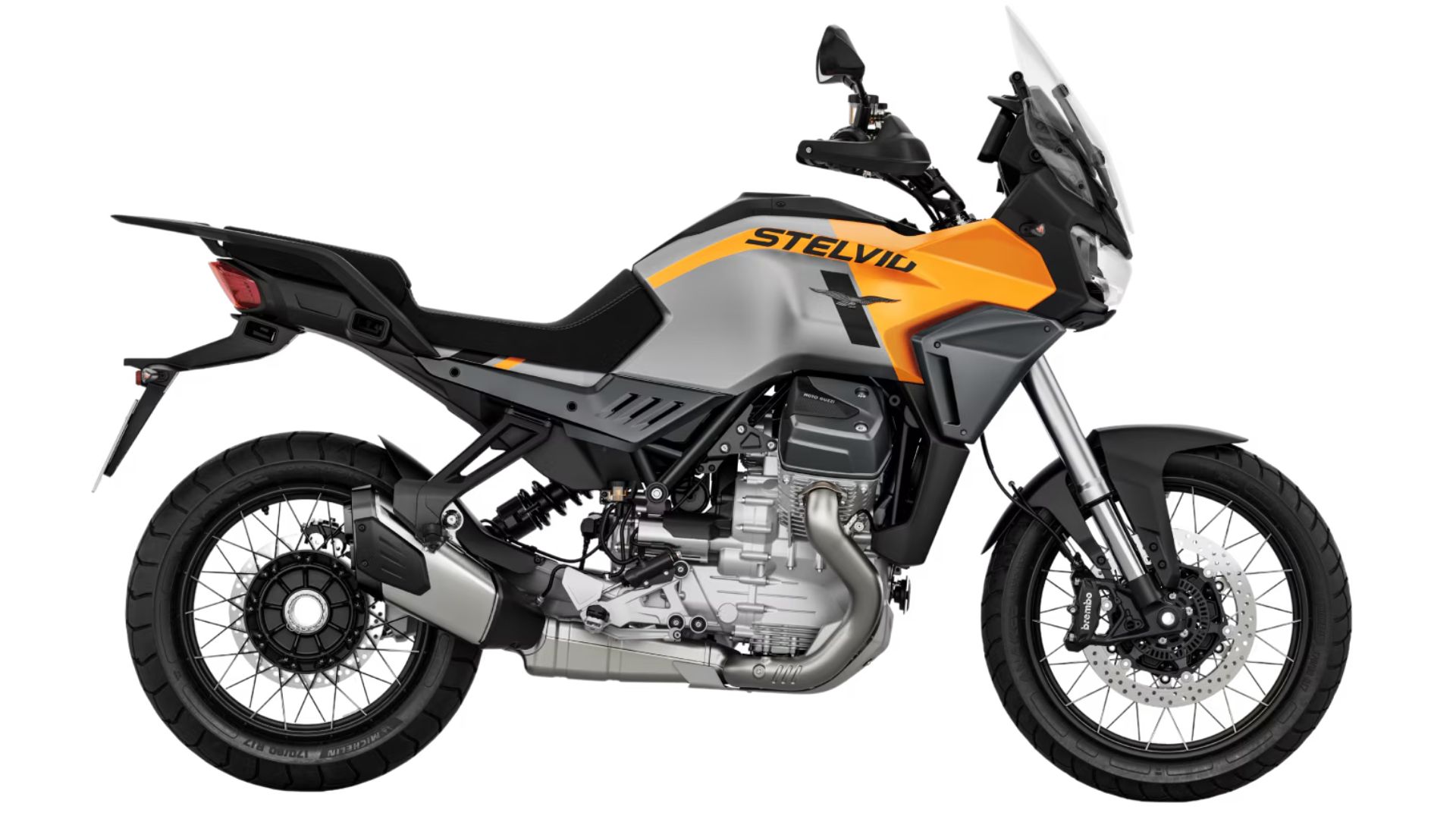 Avanturistični motocikel Moto Guzzi Stelvio v oranžno-sivi kombinaciji, prikazan v levem bočnem profilu na belem ozadju.