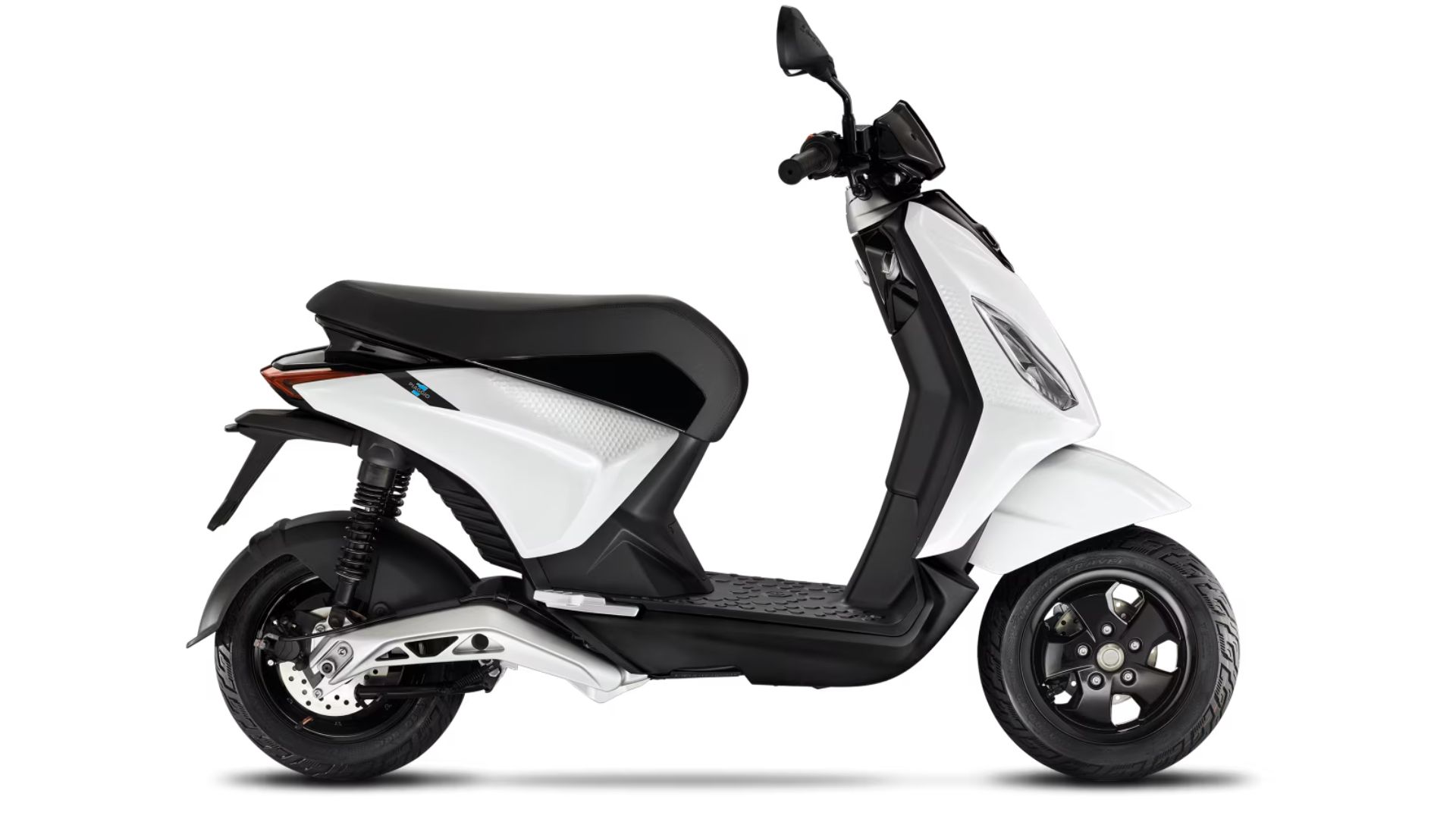 Električni skuter Piaggio 1 v beli barvi z mat črnimi detajli, prikazan v levem bočnem profilu na belem ozadju.Piaggio 1 v beli barvi, tričetrtinski pogled od spredaj desno; vidna LED-žarometa, črno krmilo z ogledali in črno platišče sprednjega kolesa.