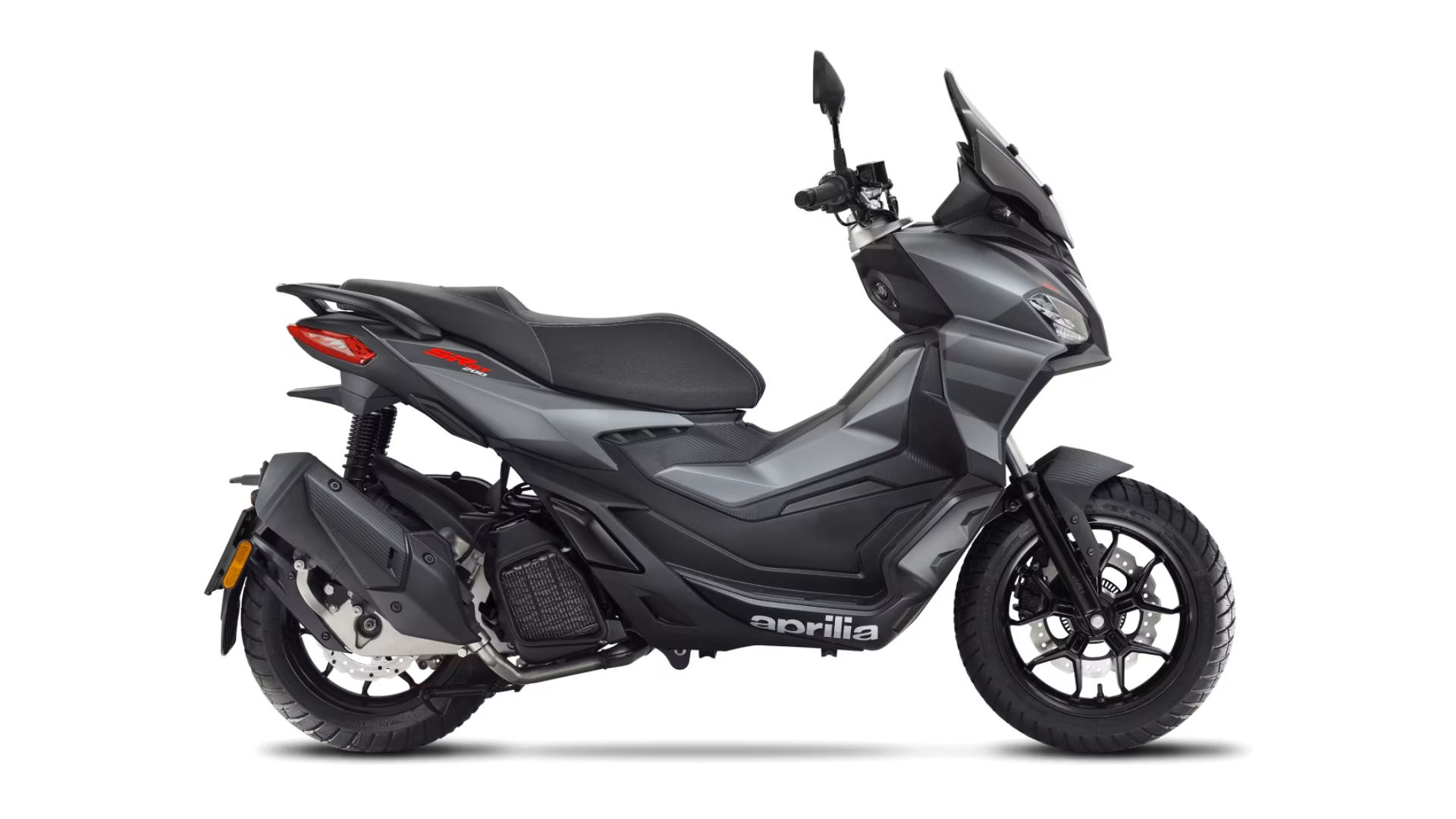 Stranski profil Aprilia SR GT v sivi barvi z visokim temnim vetrobranom in črnimi platišči, na belem ozadju.