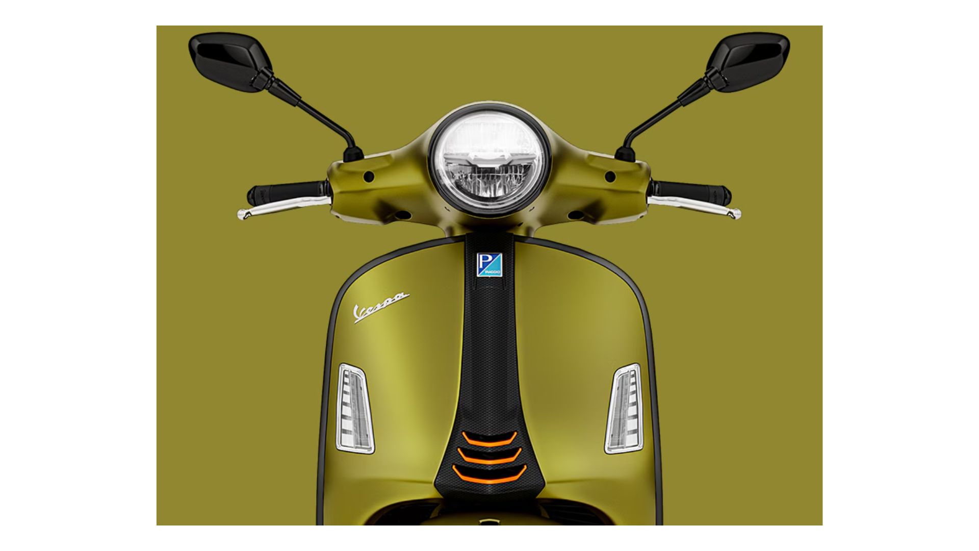A close-up of the scooter’s front view, including the handlebar area and the dashboard. It features clear instrumentation and sleek controls, with the distinct Vespa logo on the front. The modern, minimalistic design is visible with the combination of the headlamp and the intricate bodywork.