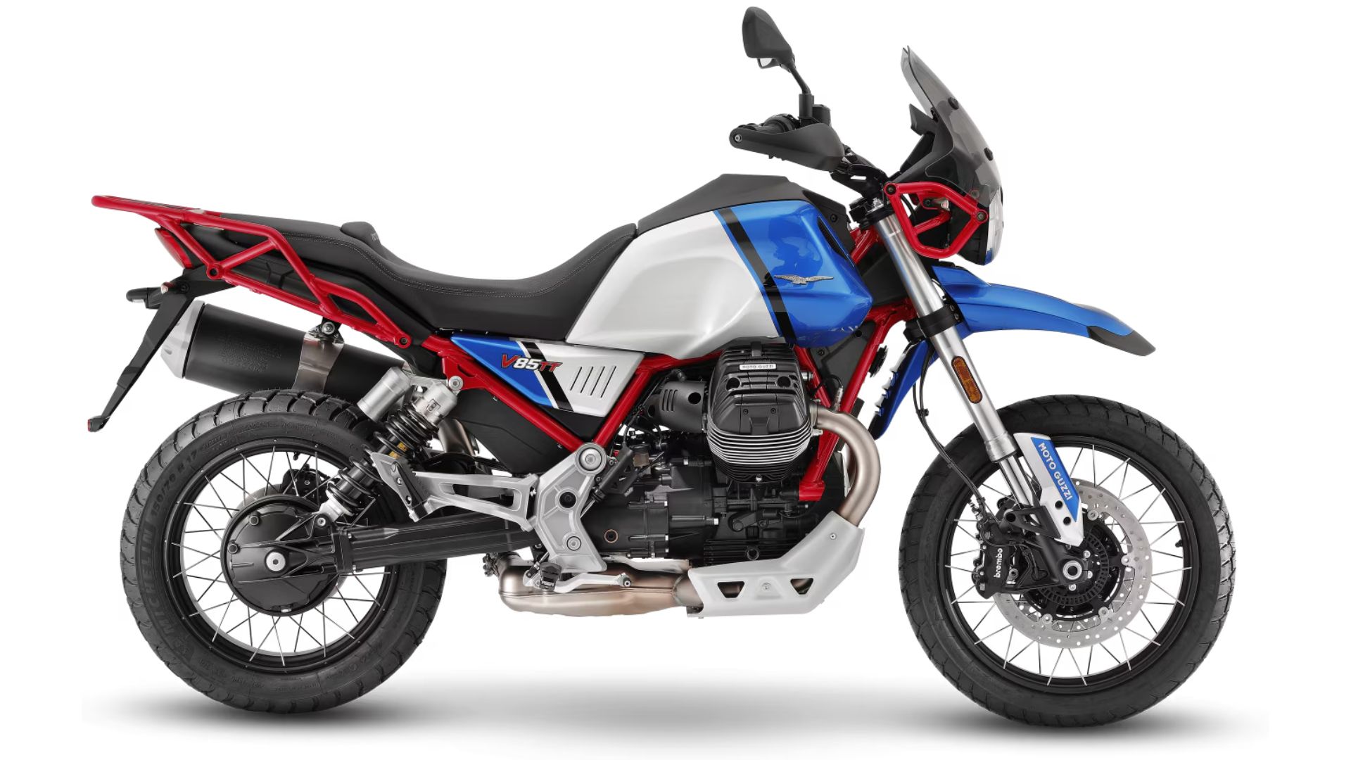 Moto Guzzi V85TT v kombinaciji modre, bele in rdeče barve, fotografiran v profilu na belem ozadju.