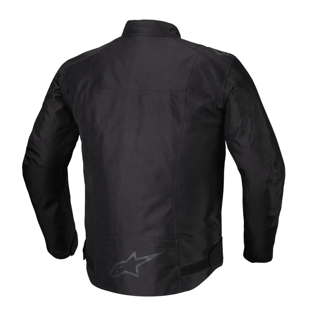 "Črna motoristična jakna Alpinestars v enobarvni izvedbi, prikazana s hrbtne strani, z drobnim temnim logotipom Alpinestars na spodnjem delu hrbta."